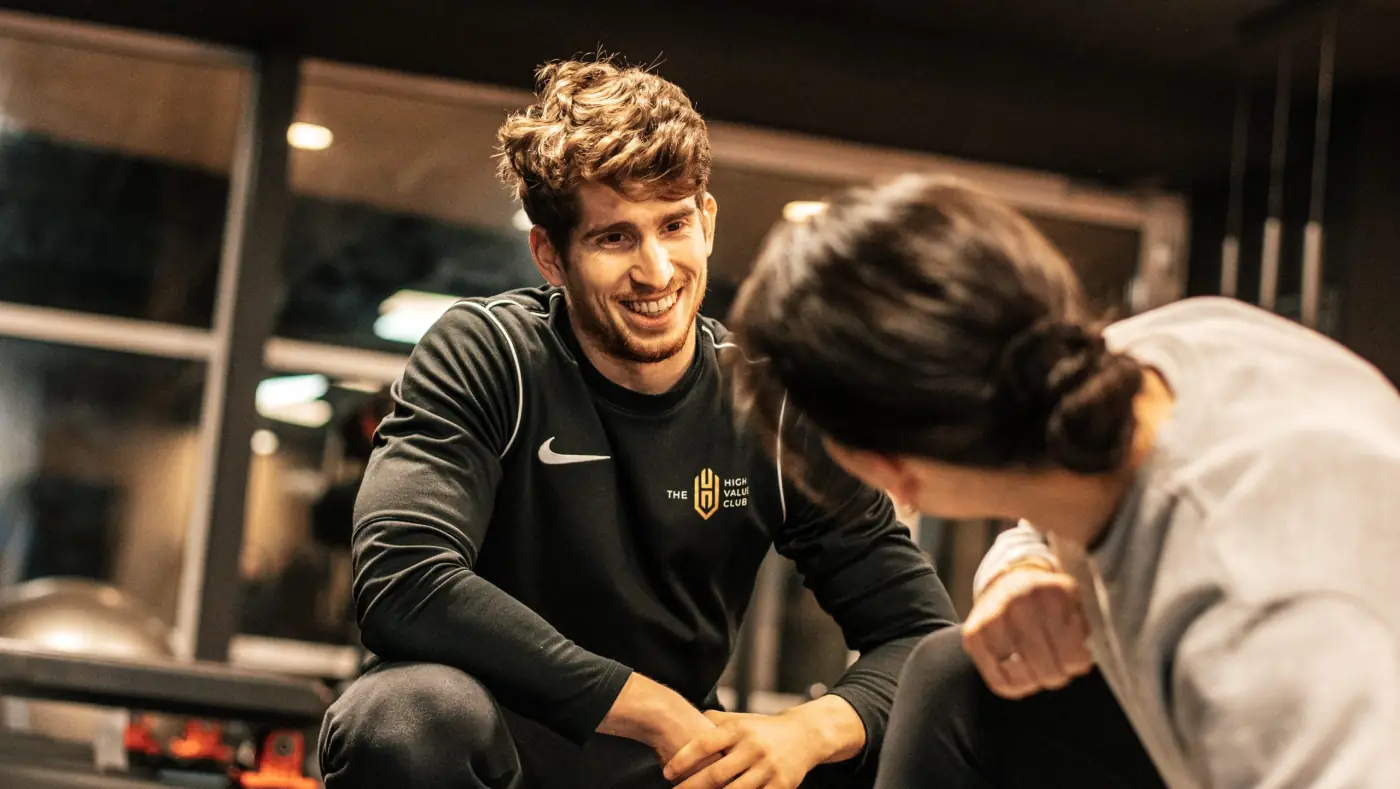 Een coach begeleidt een lid tijdens de training