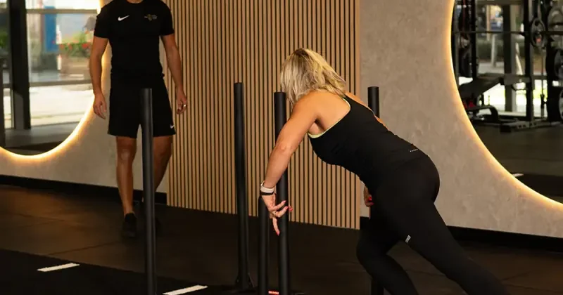 Een lid duwt een sled tijdens de training