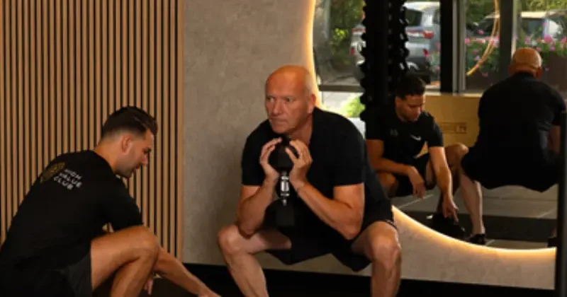 Trainer begeleidt een oefening met kettlebells