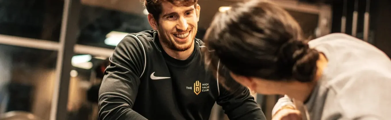 Een coach begeleidt een lid tijdens de training