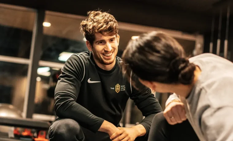 Een coach begeleidt een lid tijdens de training