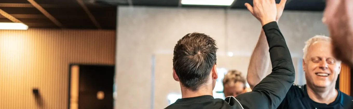 Twee leden geven elkaar een high five na de training
